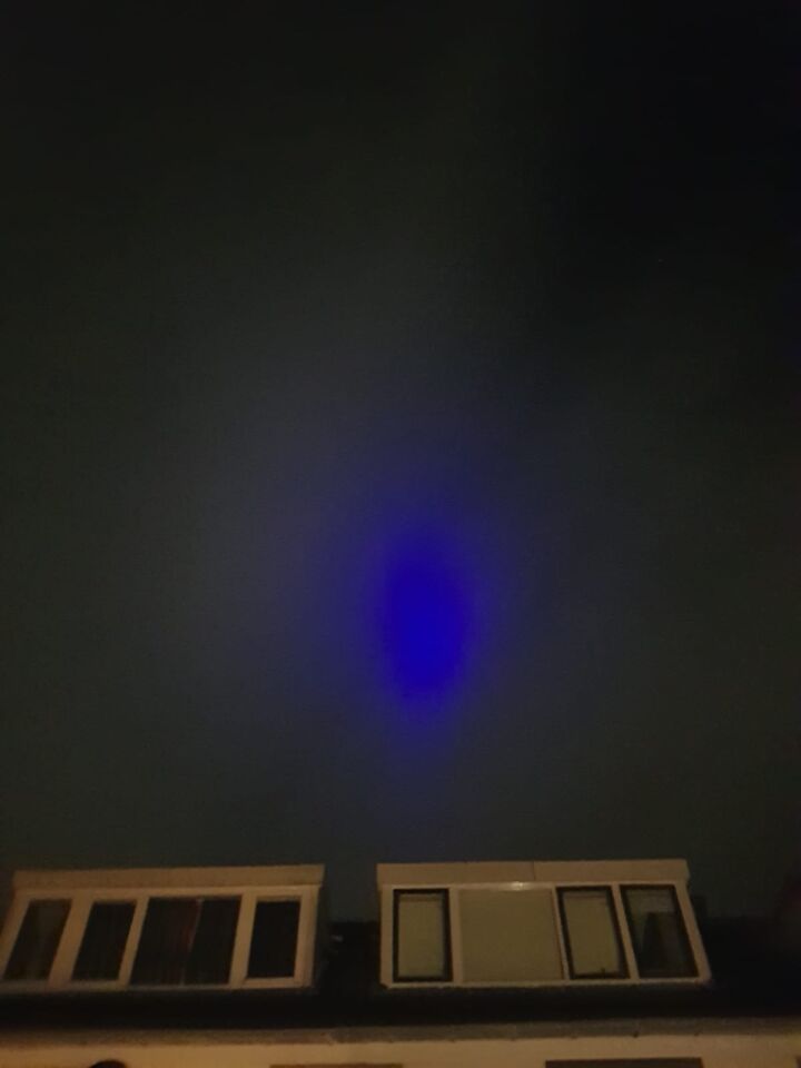 Donkerblauwe lichtbron achter wolk foto