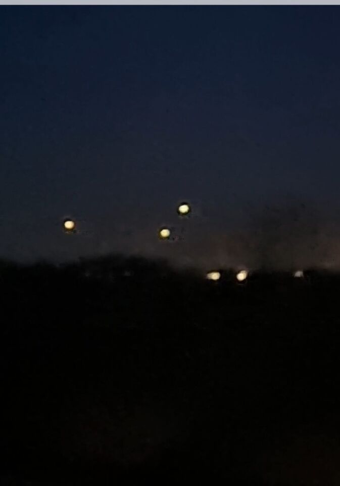 3 lichtpunten in driehoek vorm in de lucht en 1 hele felle lichtbol foto