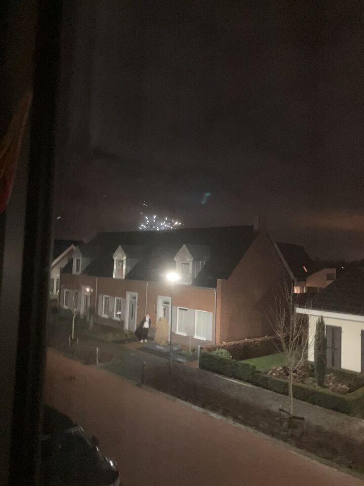 Een eivormigvoorwerp in een donkere lucht boven Sevenum met groene verlichting foto