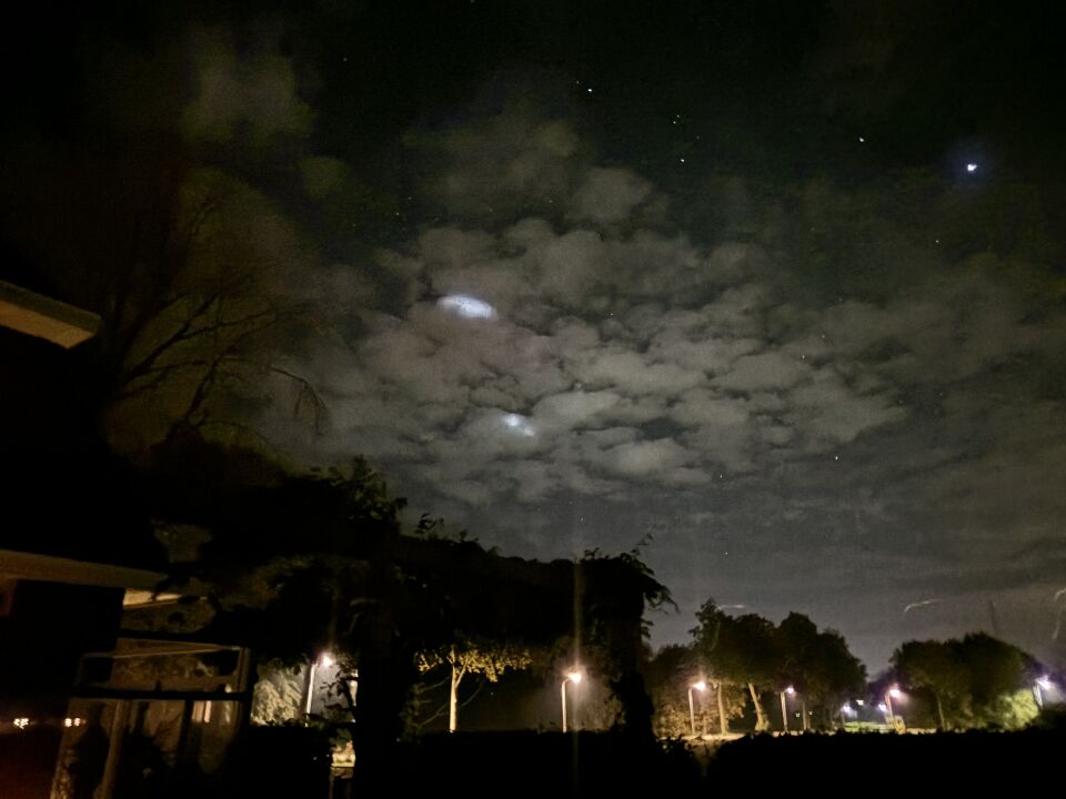 Vliegende ronde lichtobjecten achter de wolken foto