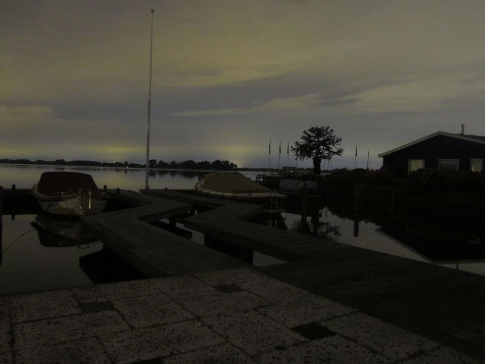 Van kleur veranderende (blauw->rood) draaiende lichtstaven laag boven het water foto