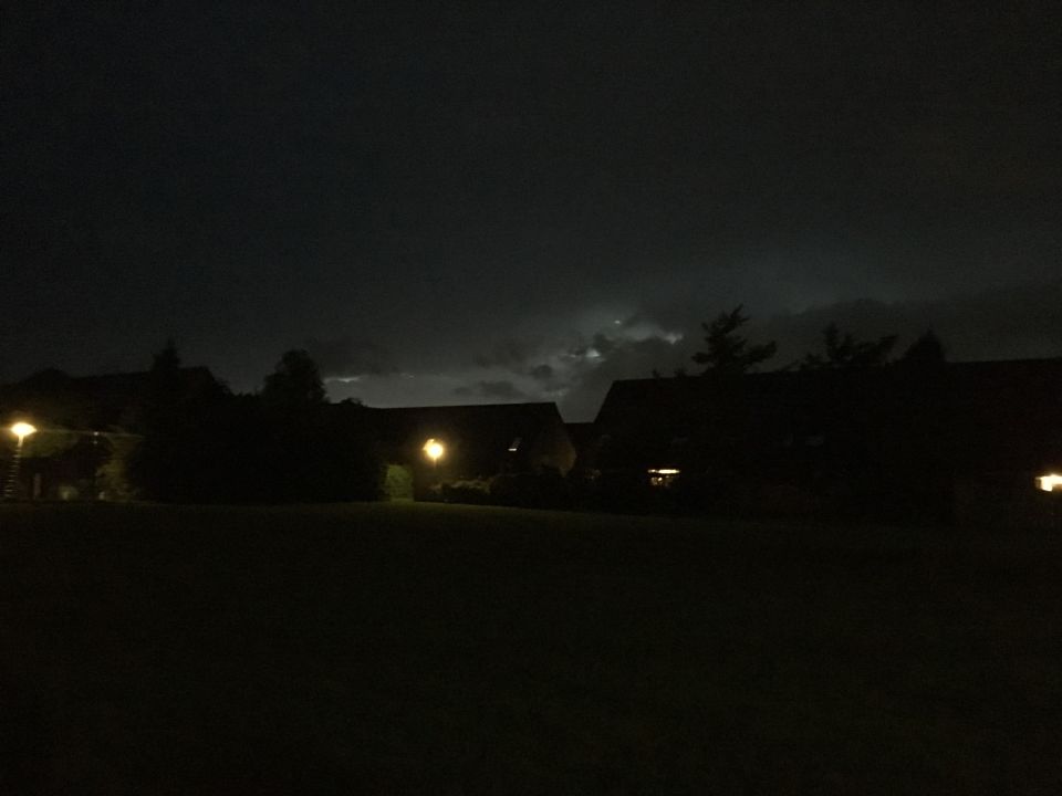 Fel licht tussen de donkere wolken en silhouet van immens vliegtuig + ronde bol foto