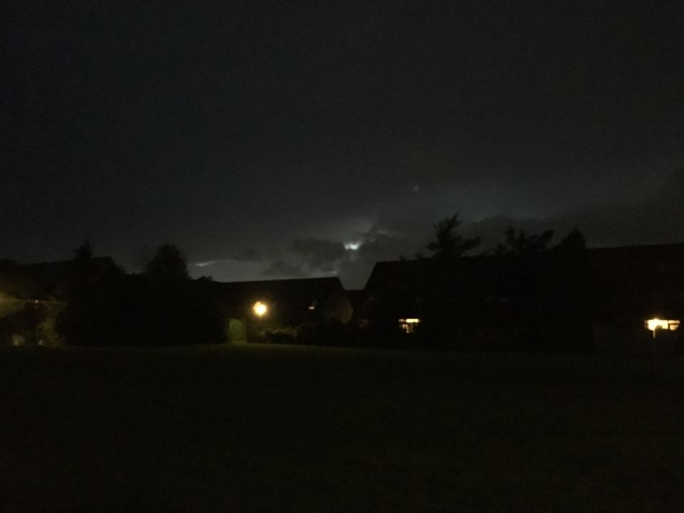 Fel licht tussen de donkere wolken en silhouet van immens vliegtuig + ronde bol foto