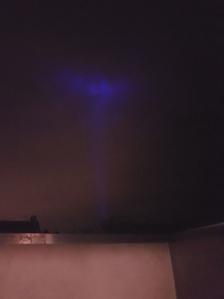 Blauwe lichtstraal dat blauwe driehoek op wolken schijnt foto